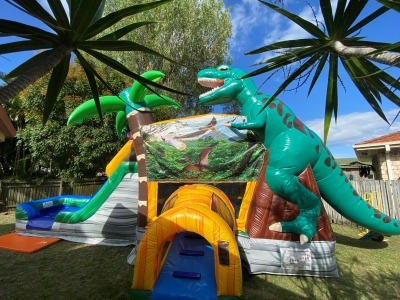 3d dinosaur castle behind trees resized Themed Jumping Castle Brisbane: Dinosaur, Unicorn, Mermaid & Princess Parties